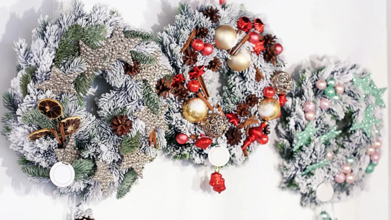 Beautiful Christmas wreaths made by professional florist hanging on light wall