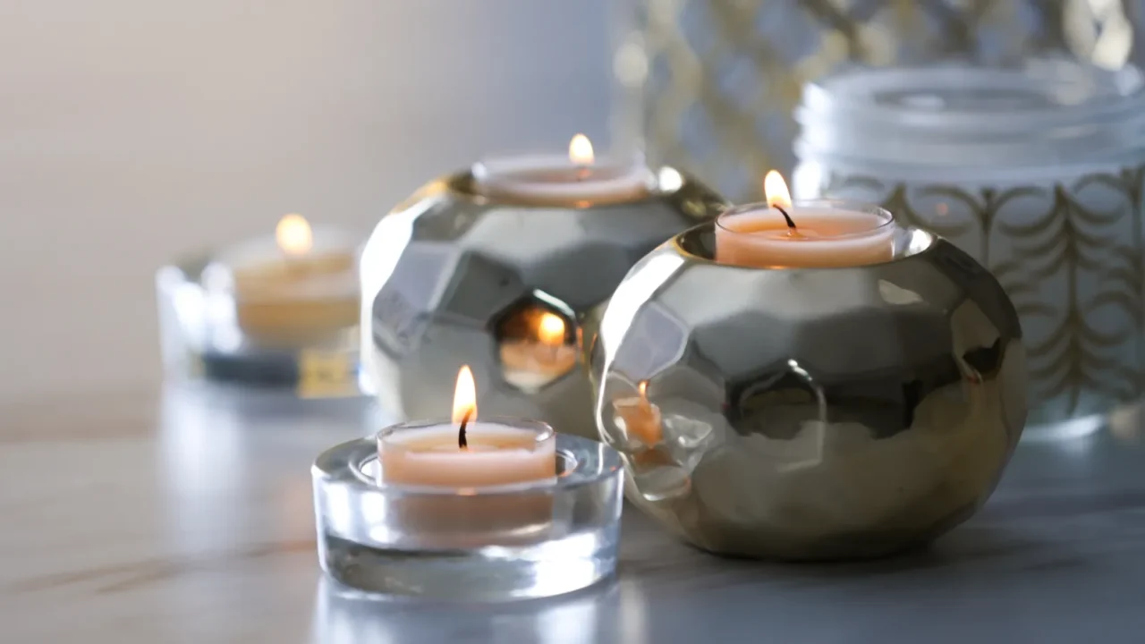 Burning candles in holders on white marble table indoors