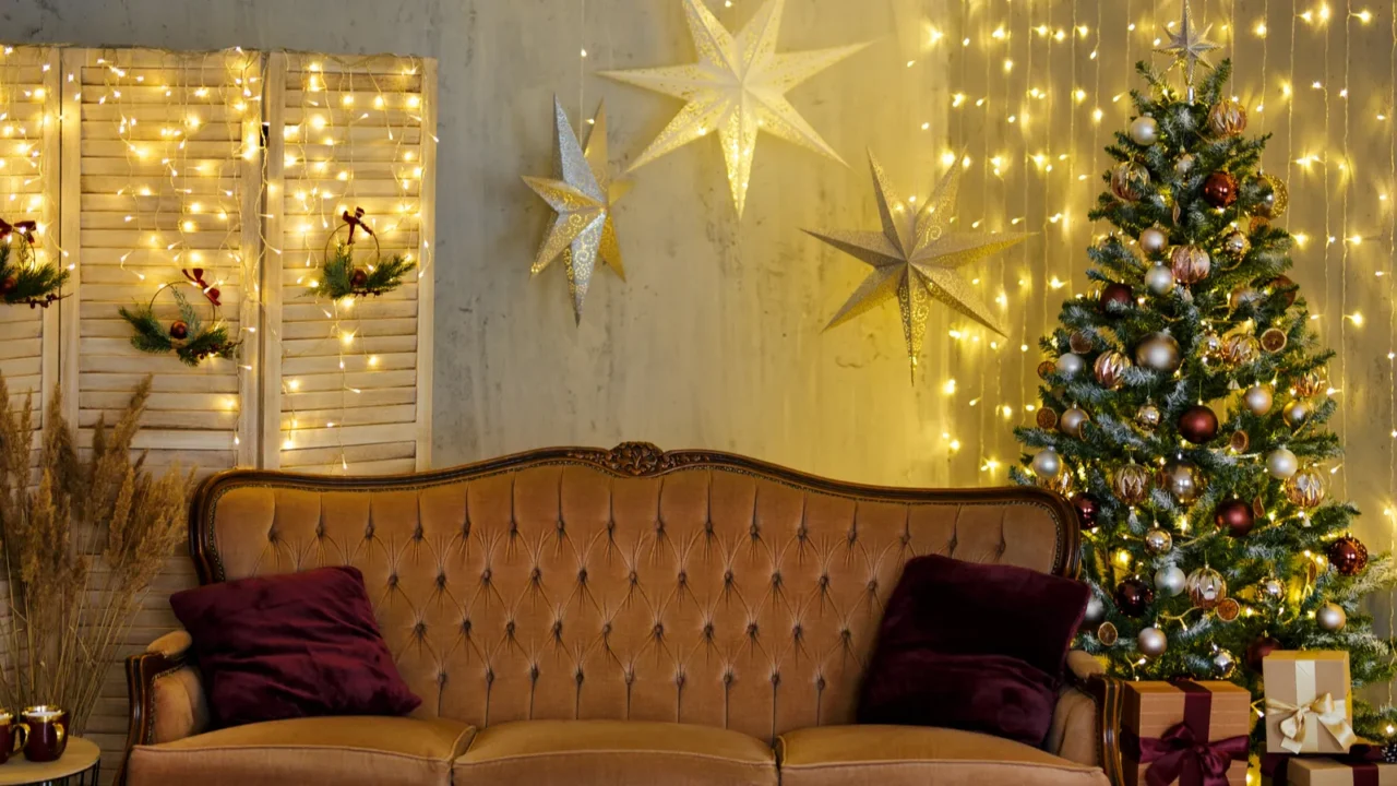 Christmas background - living room with decorated Christmas tree, vintage sofa, festive garland led lights and wrapped gift boxes