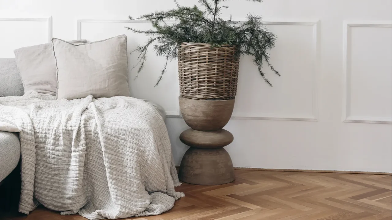 Christmas interior. Two blank vertical wooden picture frames mockups. White wall background.. Bed, sofa with linen cushions, blanket. Larch, pine tree branches in wicker basket. Wooden coffee table.