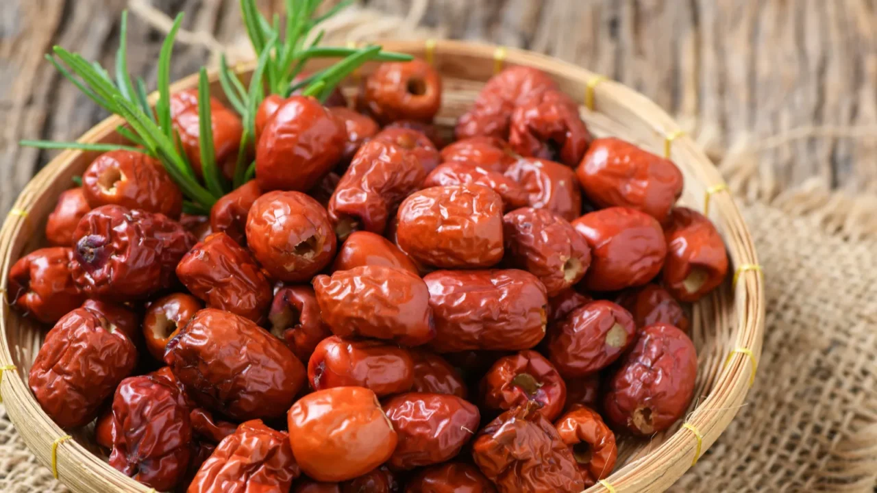 Dried Jujube, Chinese dried red date fruit in bamboo basket on old wood background,herbal fruits. It have more vitamin C Which helps fight free radicals And stimulate the immune system