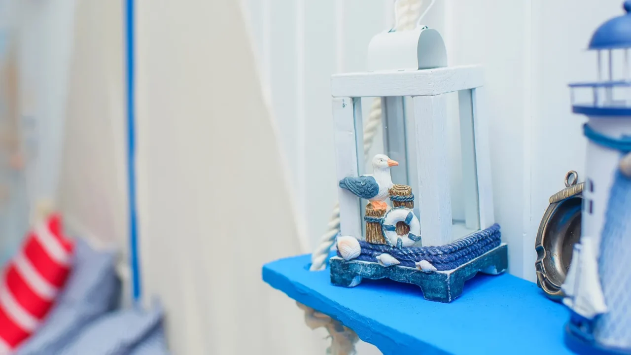 Interior decor in the marine style. Paper garland on the background of bright walls. Blue wooden shelves on ropes.