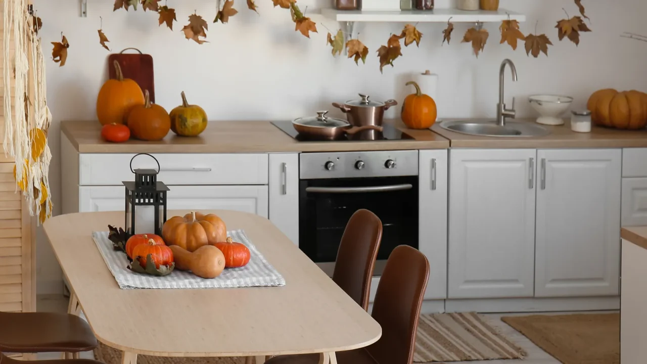 Interior of light kitchen decorated for Halloween with dining table and counters