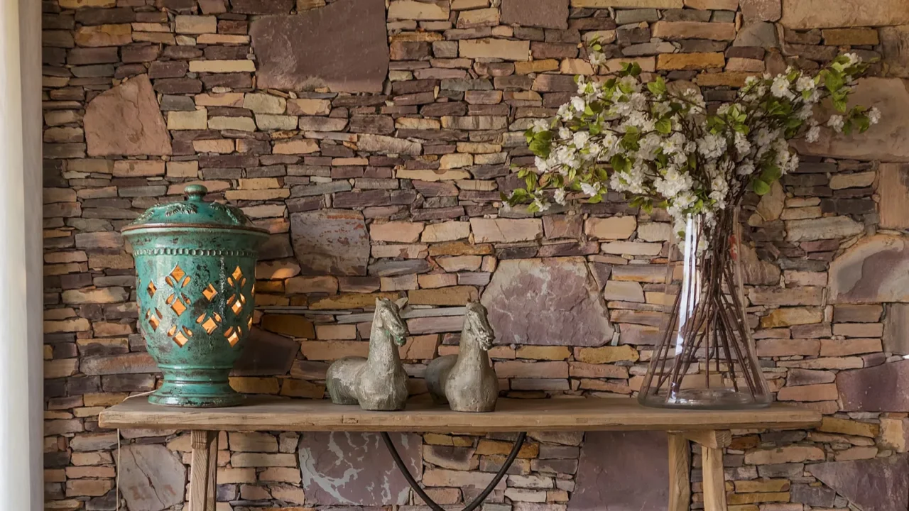 Living room with decorative table, stone wall behind.