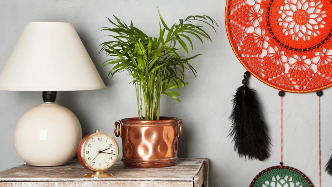 Orange dream catcher in bedroom interior on gray textured background. Bedroom decor and copy space for text