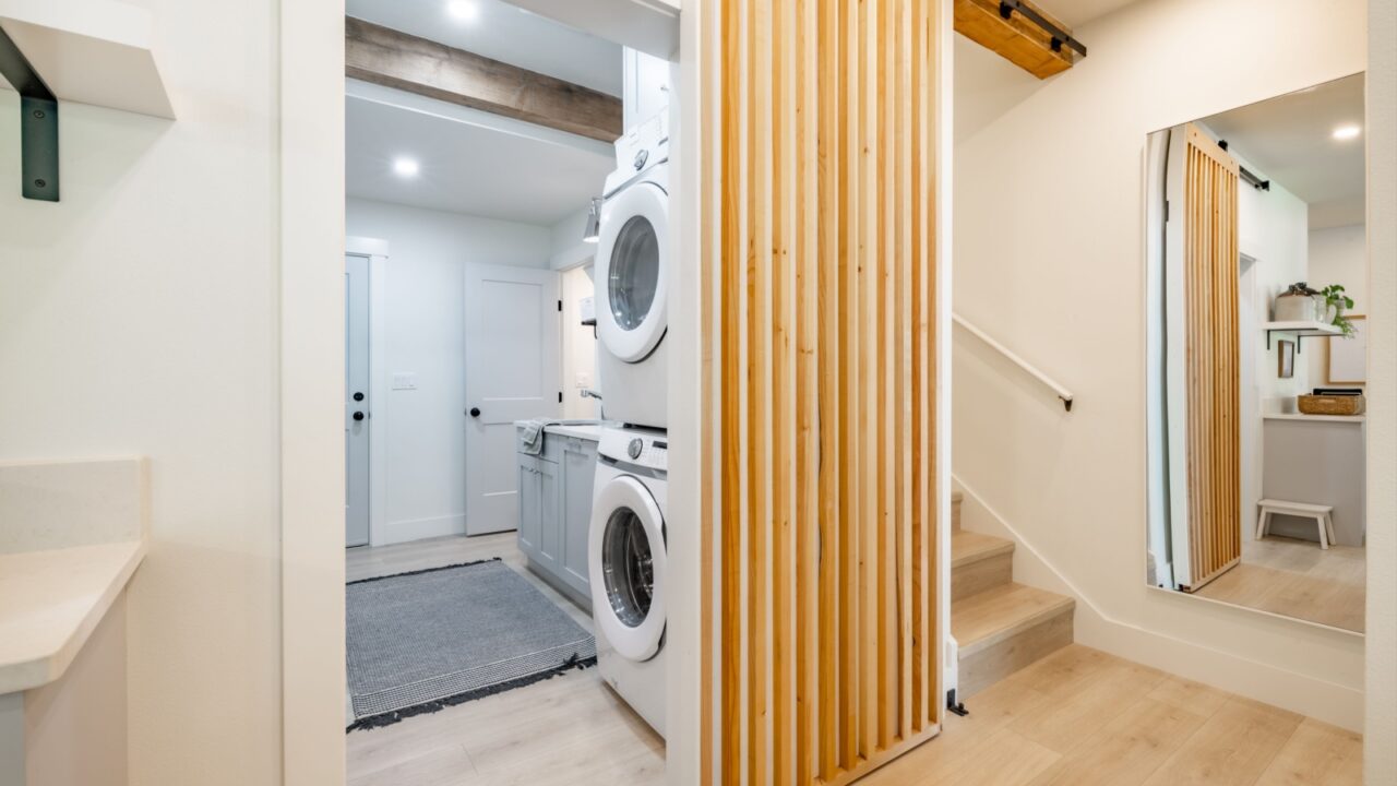 laundry room and hallway with stairs barn door hardwood floors