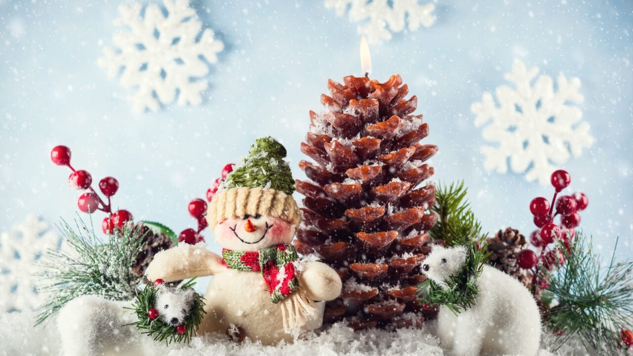 Snowman, white bears and Christmas candle in shape pinecone in the snow