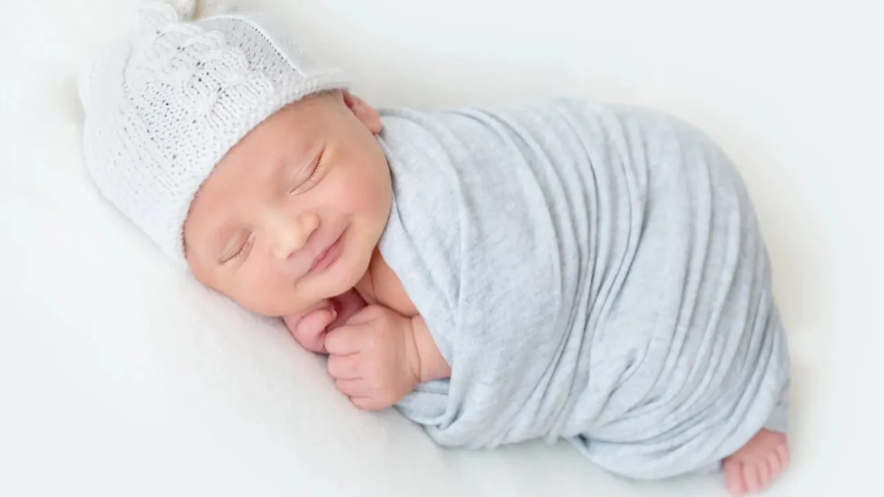 Sleeping newborn baby swaddled in a light blue wrap