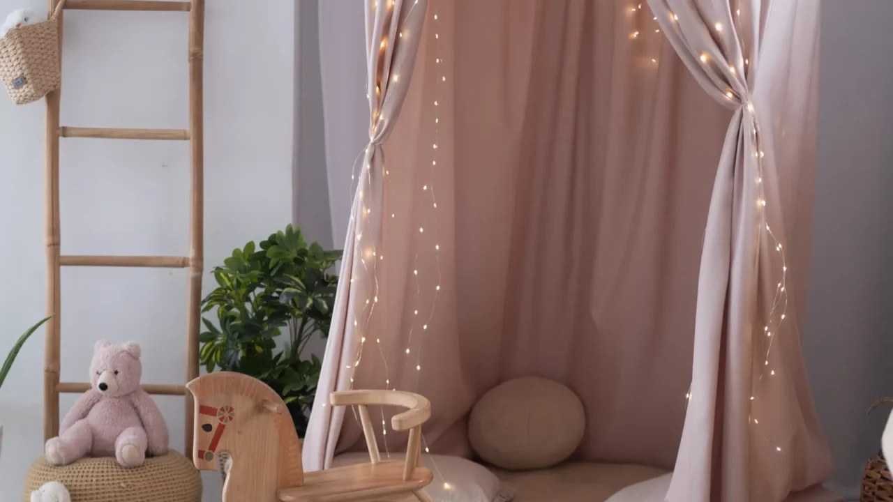 This inviting children's play area features a wooden rocking horse, soft cushions, and plush toys, all surrounded by gentle fairy lights, creating a warm and playful atmosphere.