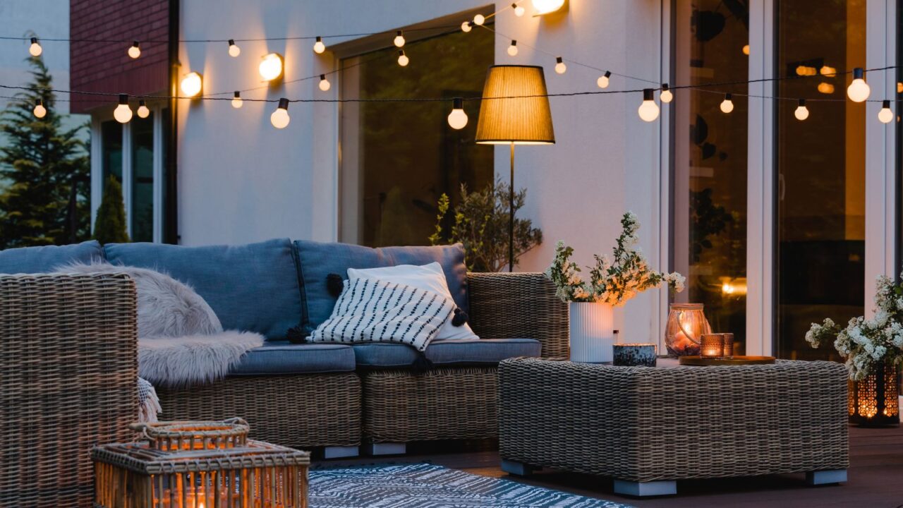 Evening on the patio of beautiful suburban house with lights in the garden.