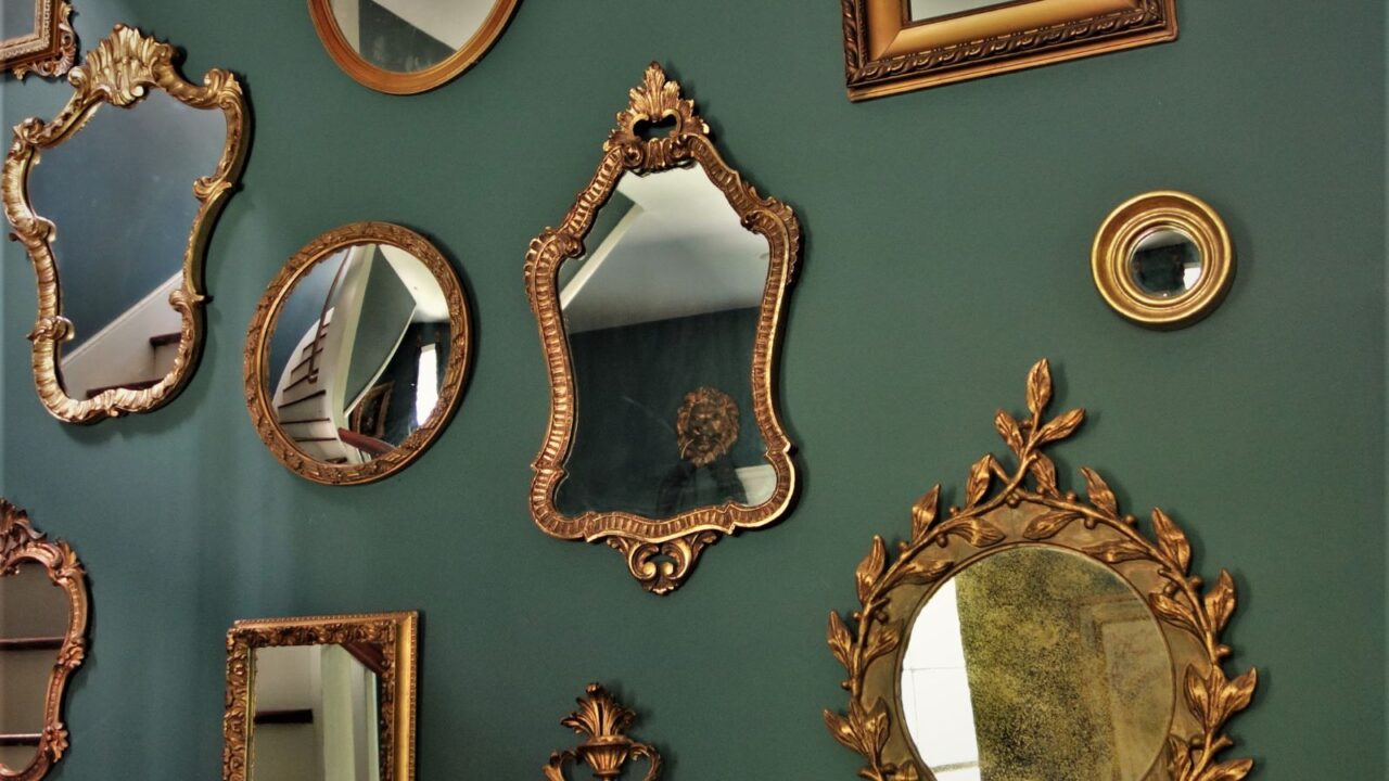 Different vintage mirrors hung in stairwell.