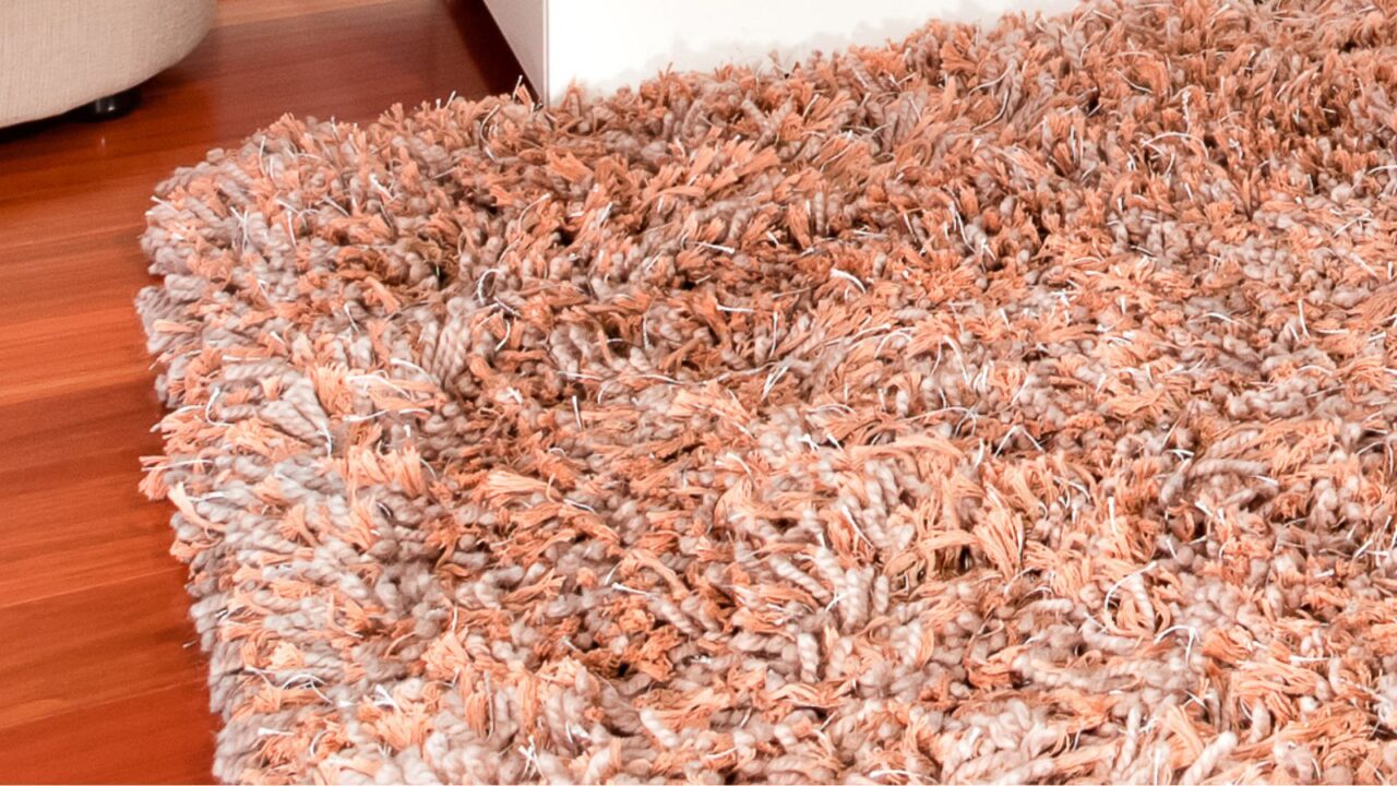 A high-pile shag area rug on a wooden floor.