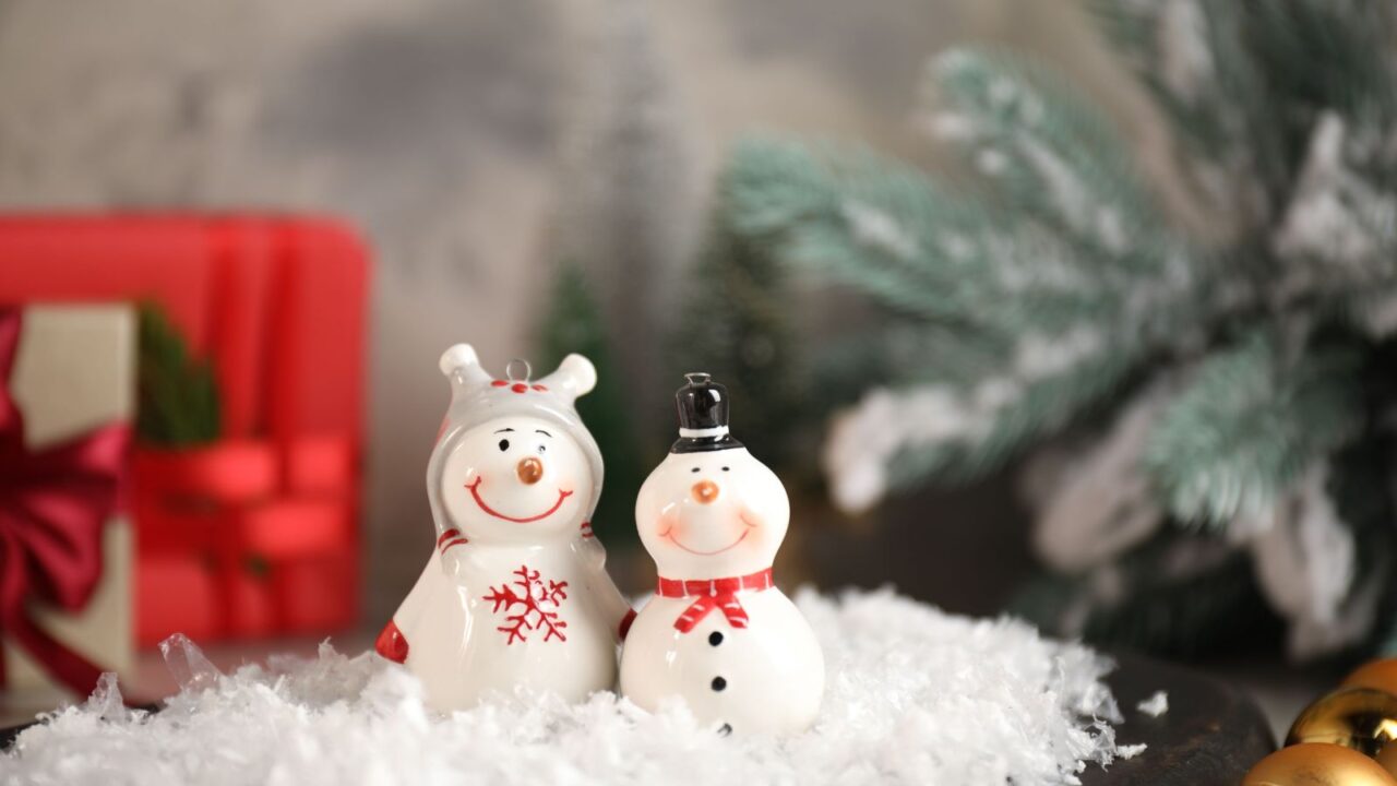 Cute snowmen figures with faux snow on a table