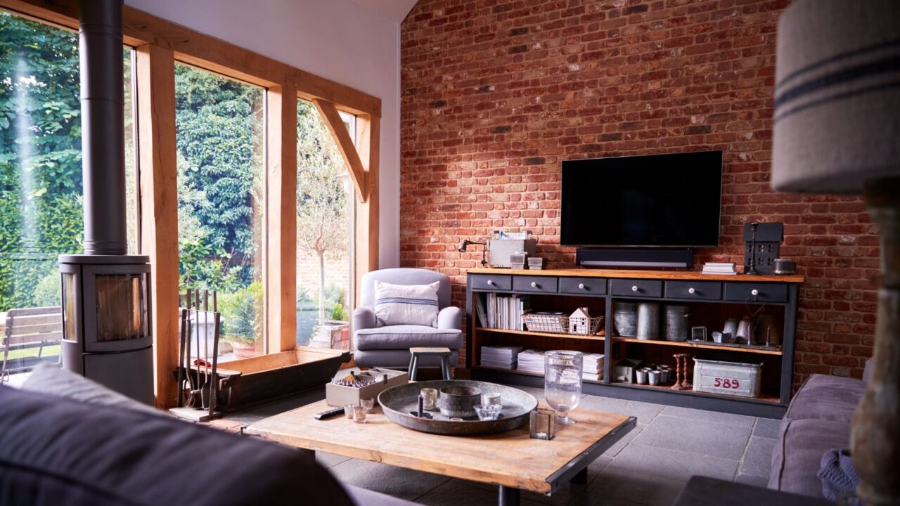 Interior of lounge with TV and exposed brick walls in modern open plan house or apartment.