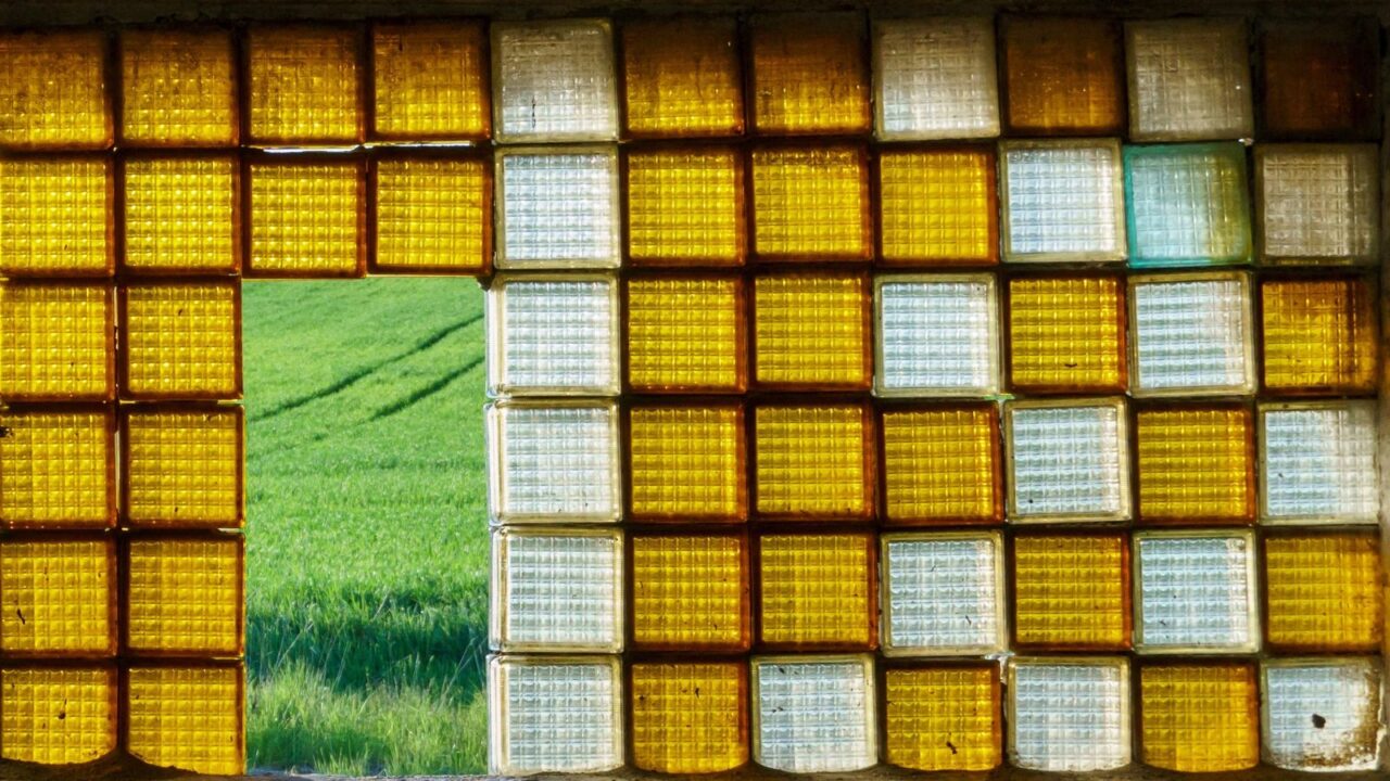 An old window made of glass blocks. Beautiful decorative orange glass blocks.