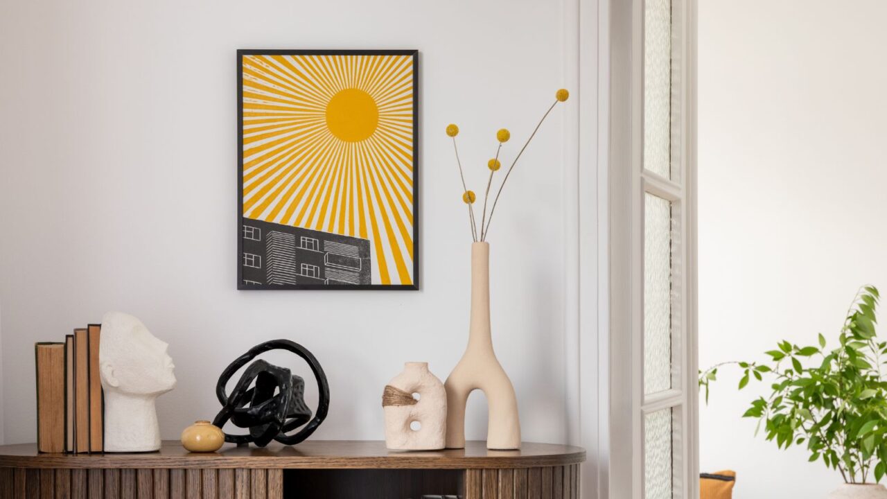 Stylish interior with a wooden cabinet plants, decorative objects, and books. A vibrant mock up art piece featuring a nature-inspired sunburst design adds a pop of color. Minimalist home decor.