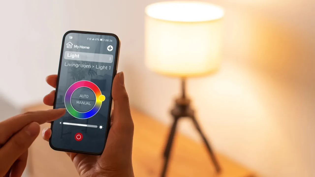 Woman controlling smart lighting at home, she is setting light color using her smartphone