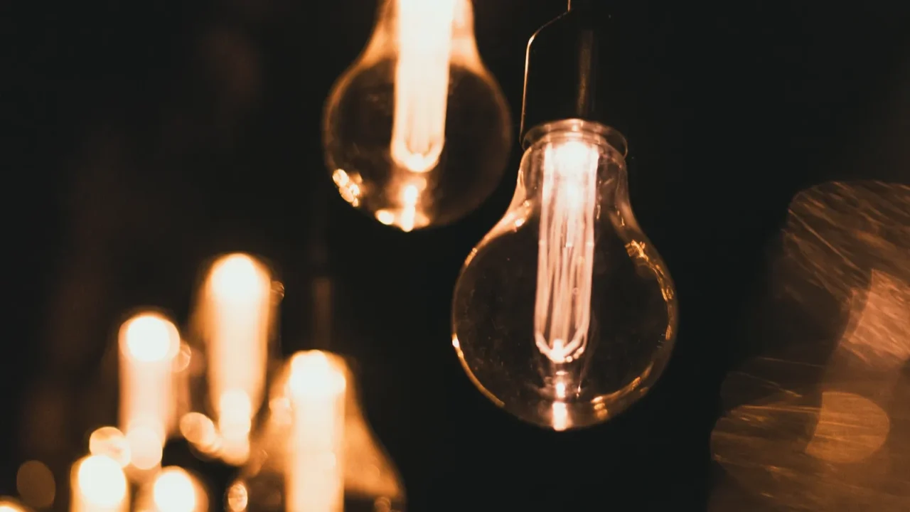 Yellow retro bulbs hanging outdoors. Light bulbs hanging on a wooden bridge at night.