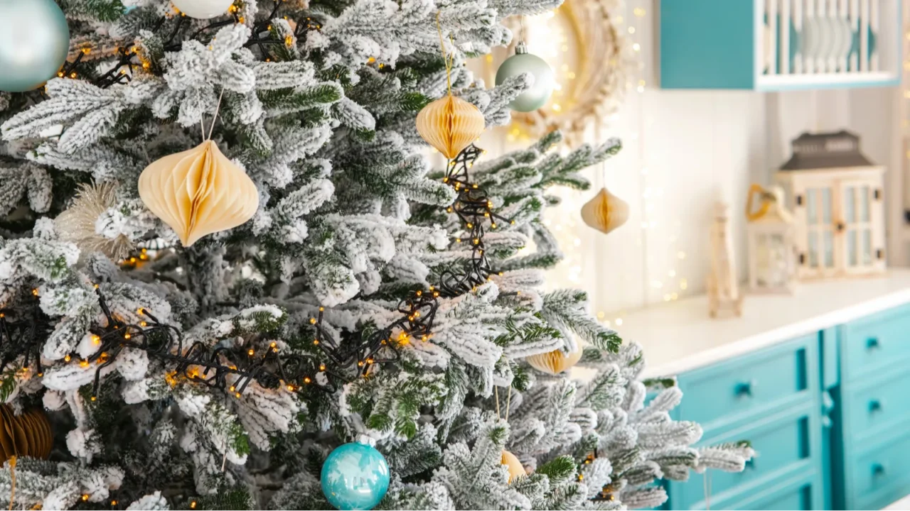 a beautifully decorated christmas tree with frosted branches and teal