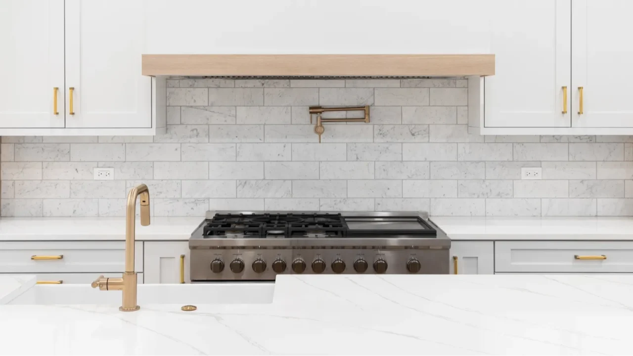 a kitchen detail with gold faucet and hardware a marble