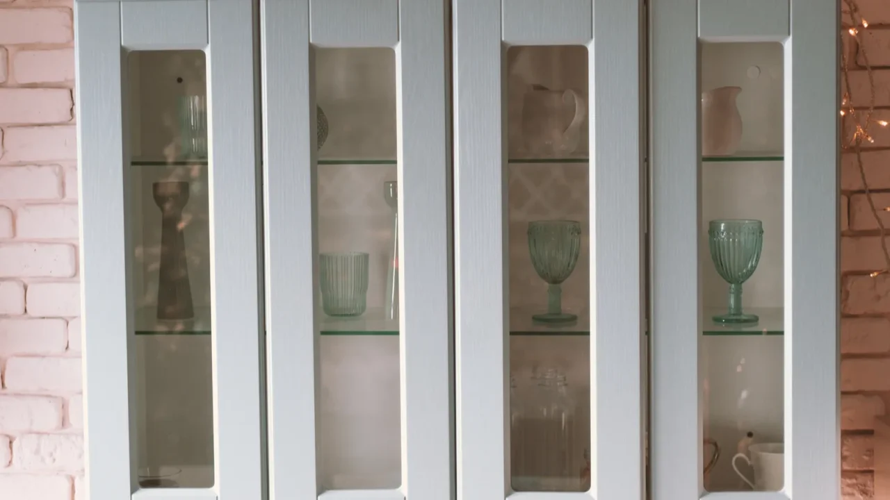 a modern glass cabinet displays elegant glassware while festive decorations