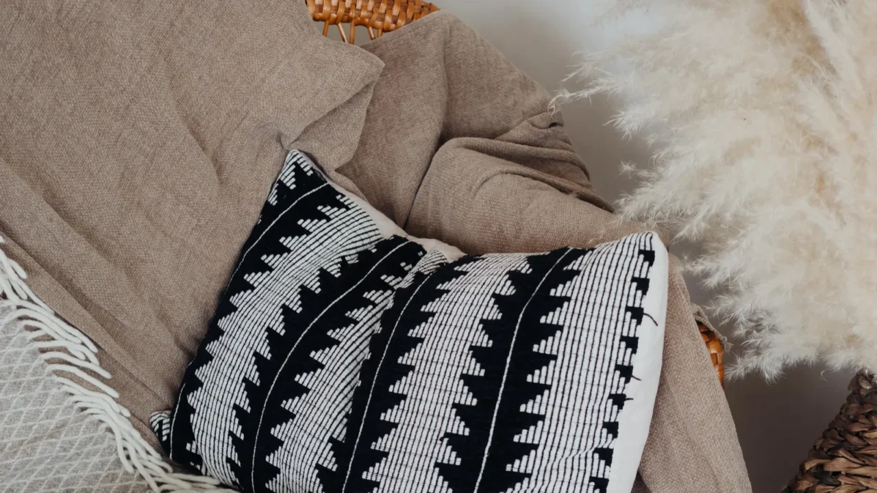 Cozy textured, patterned throws and a pillow on a chair.