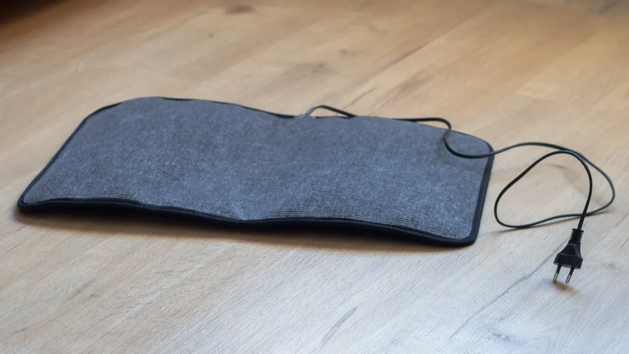 an electric mat for drying wet shoes lies on the