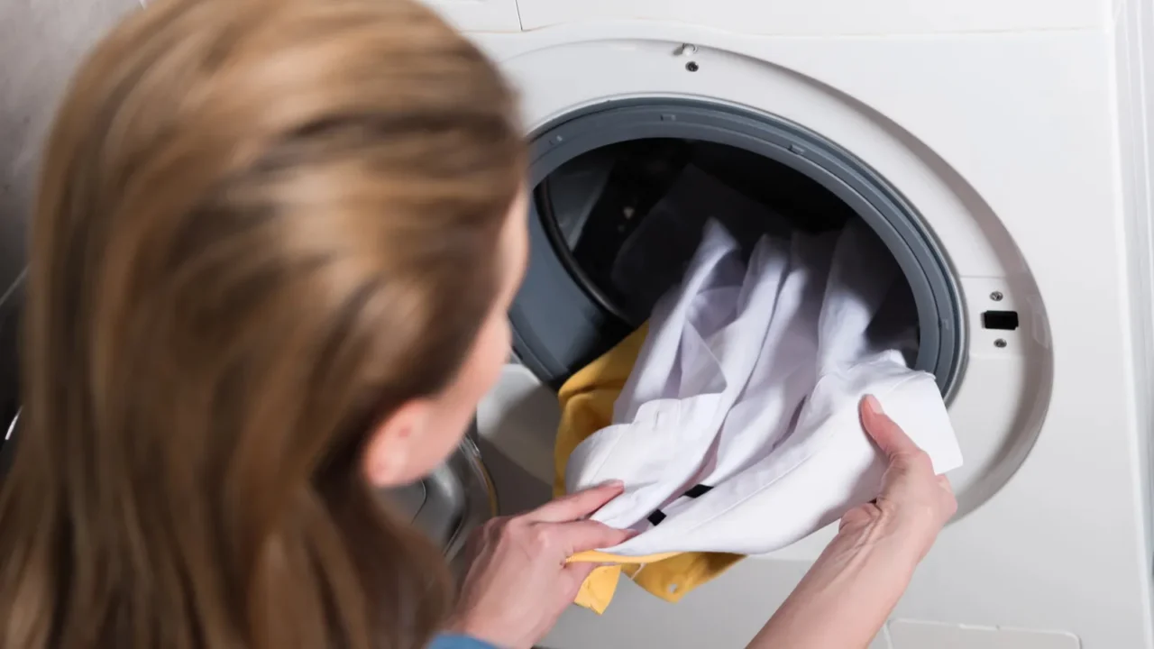 back view of housewife taking out laundry from washing machine