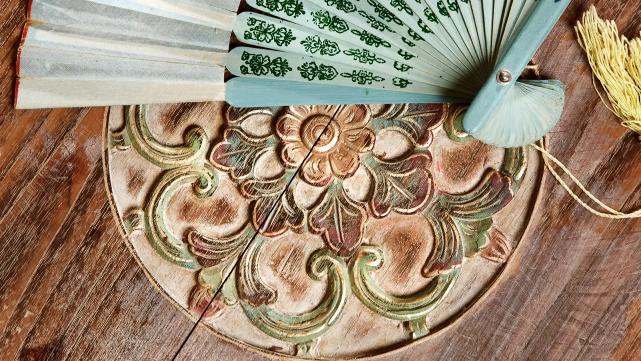 Balinese carved furniture with bali fan on the table in orient style.