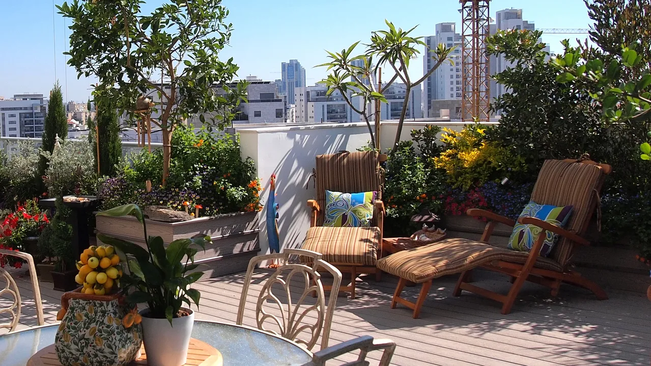 Beautiful blooming rooftop garden with a 2 chairs for relaxation and a separate dining table set of 4.