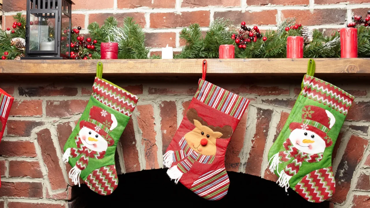 beautifully decorated santa christmas socks hanging on a fireplace in