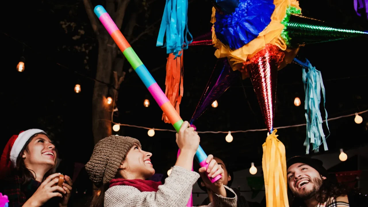 breaking a pinata celebrating a mexican posada in christmas mexico