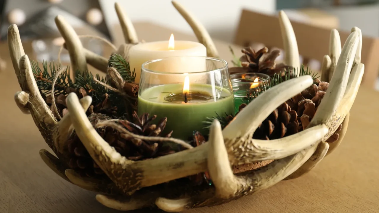 burning scented conifer candles with christmas decor on wooden