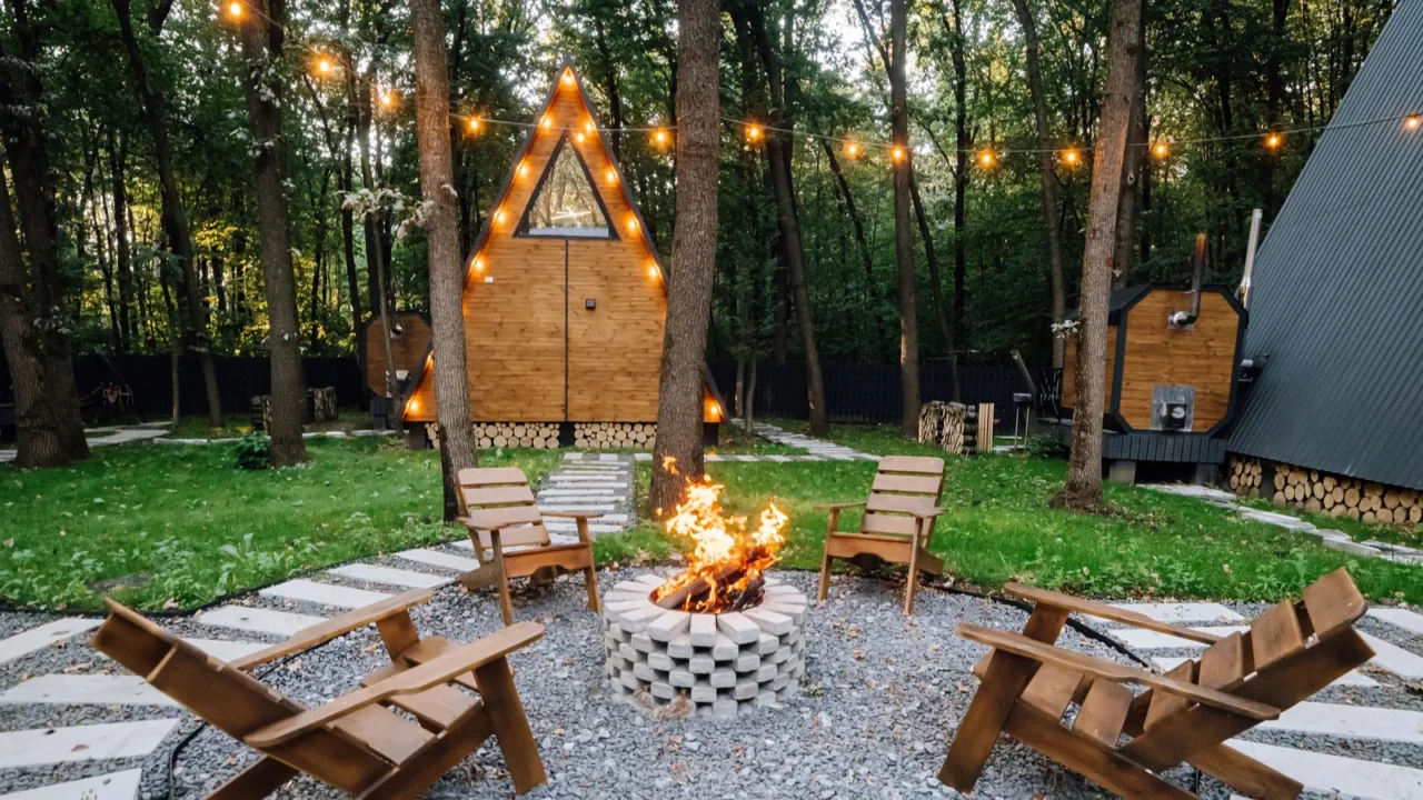 campfire area with wooden chairs and cabins in background creating