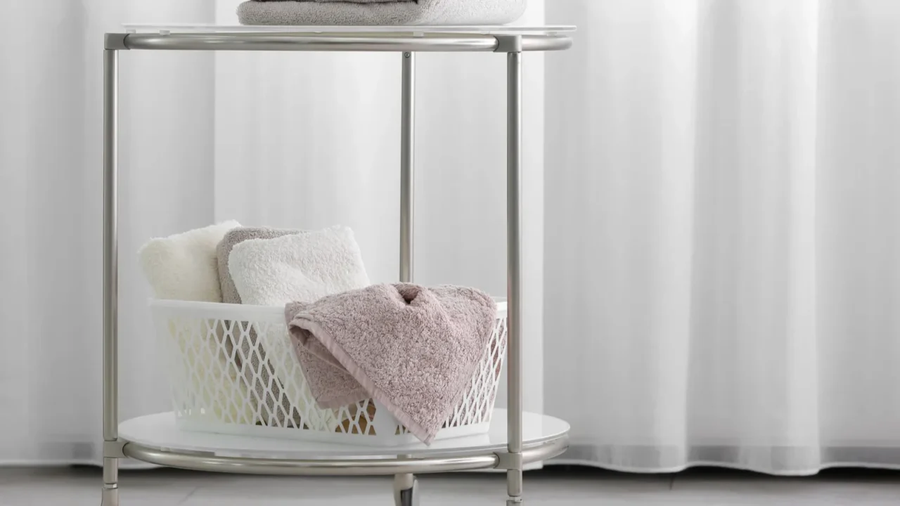 A bathroom rolling cart with clean towels indoors.