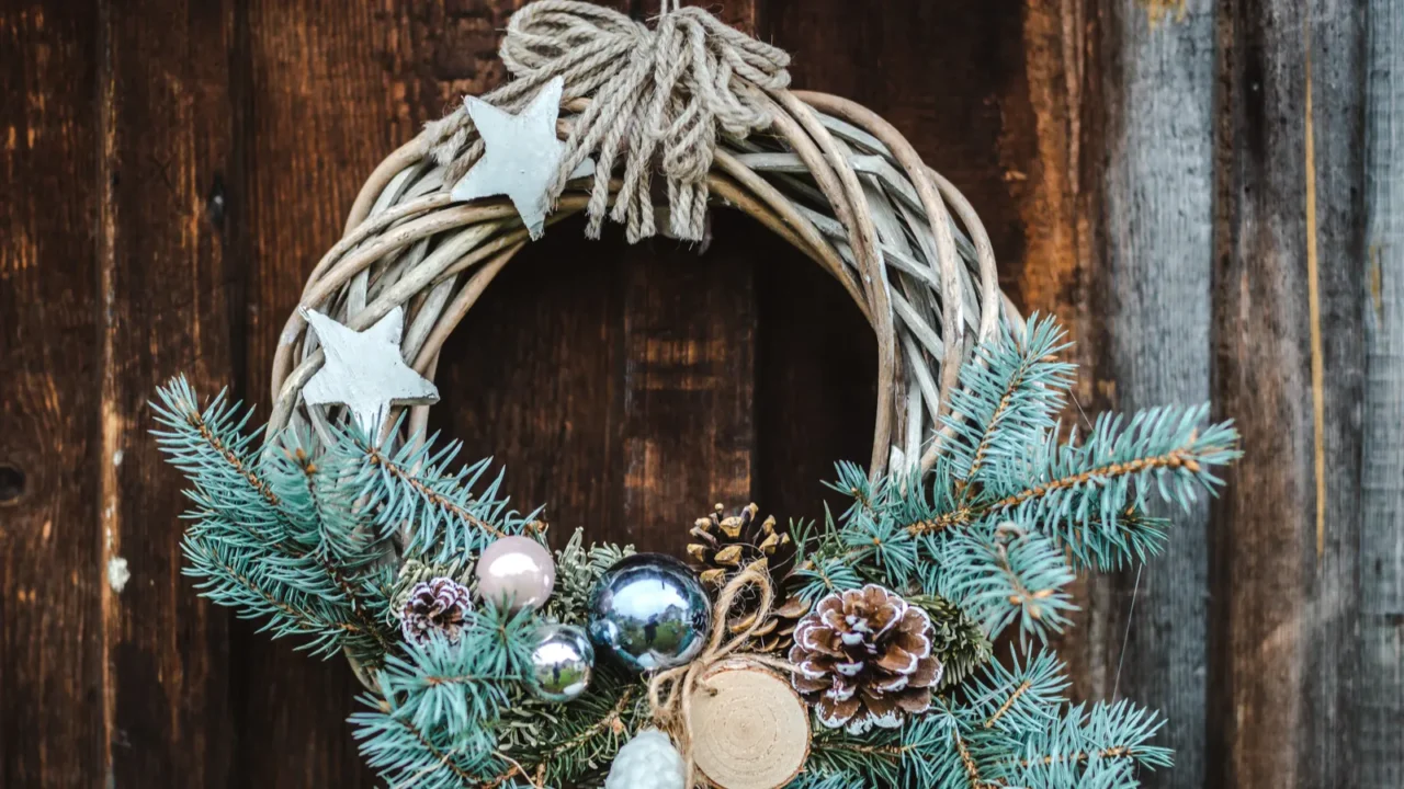 christmas wreath on rustic wooden door background of blue tree