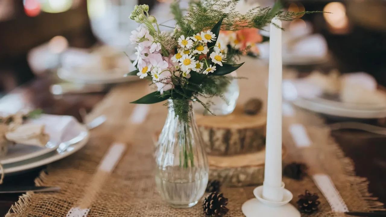 Decorations and wildflowers on festive table with burlap table runner.