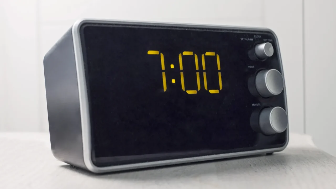 digital alarm clock with yellow digits showing seven oclock