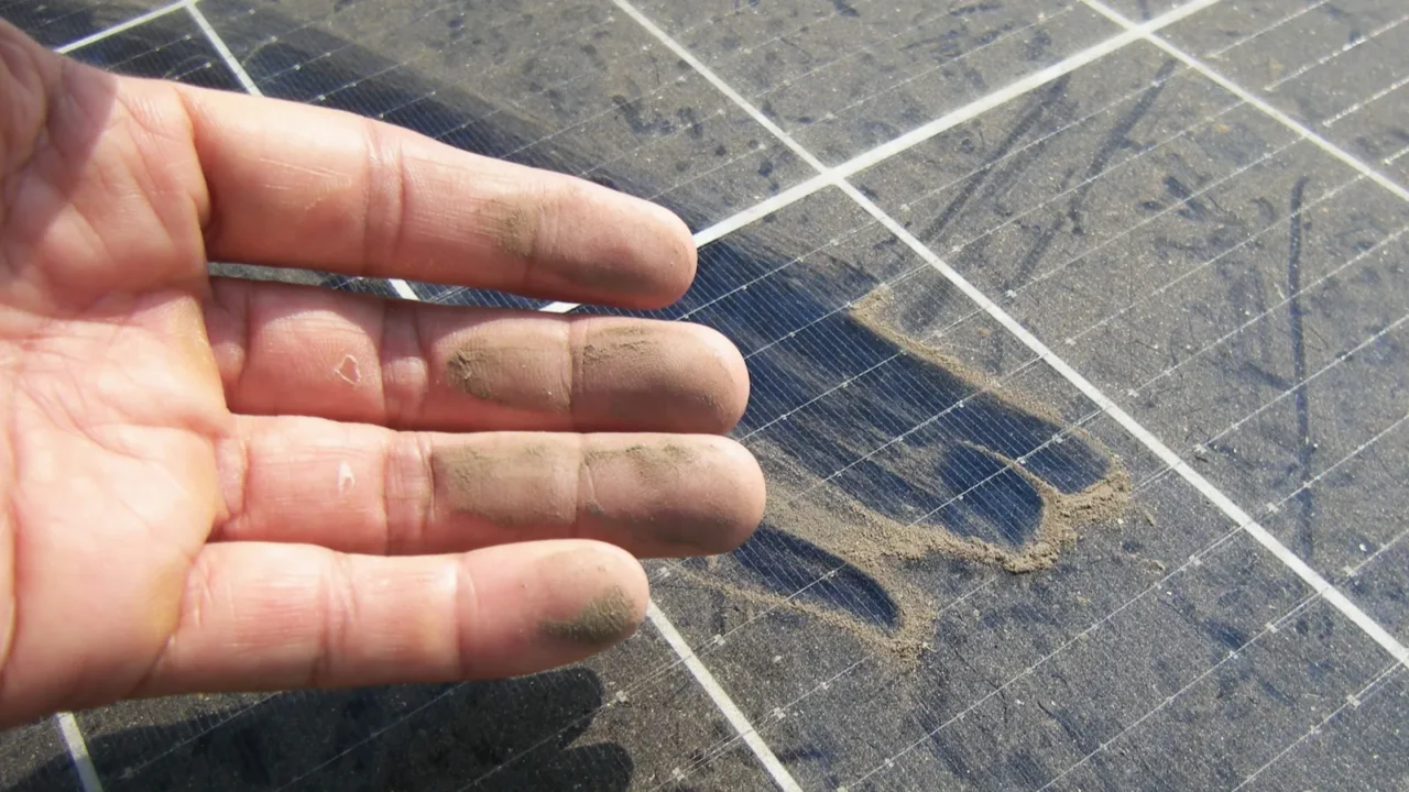 dirty hand after rubbing dusty solar panel