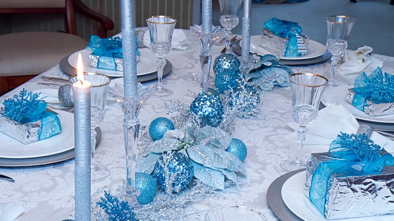 Elegant blue and silver candles and decoration for Christmas dining table. Glitter candles and glitter baubles and dining table decor..