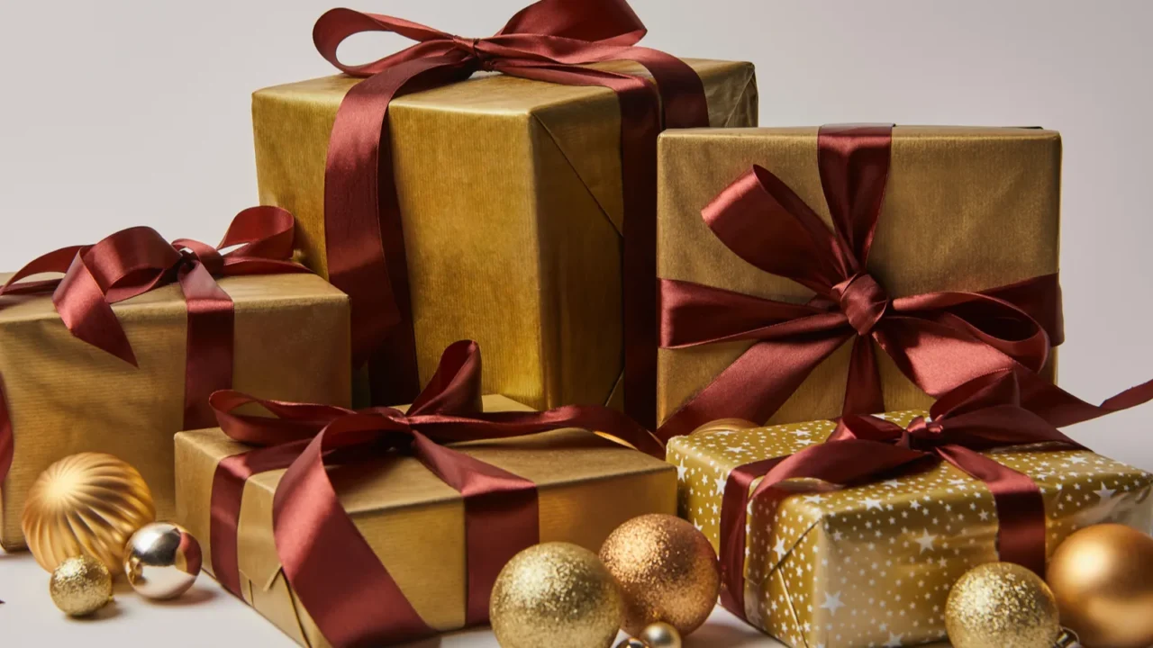 golden christmas gift boxes with burgundy ribbons and baubles isolated