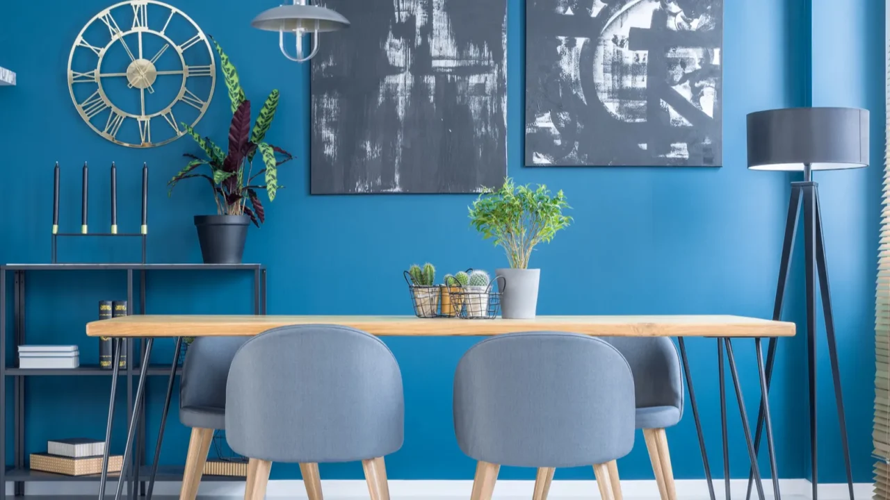 grey chairs at wooden table in blue dining room interior