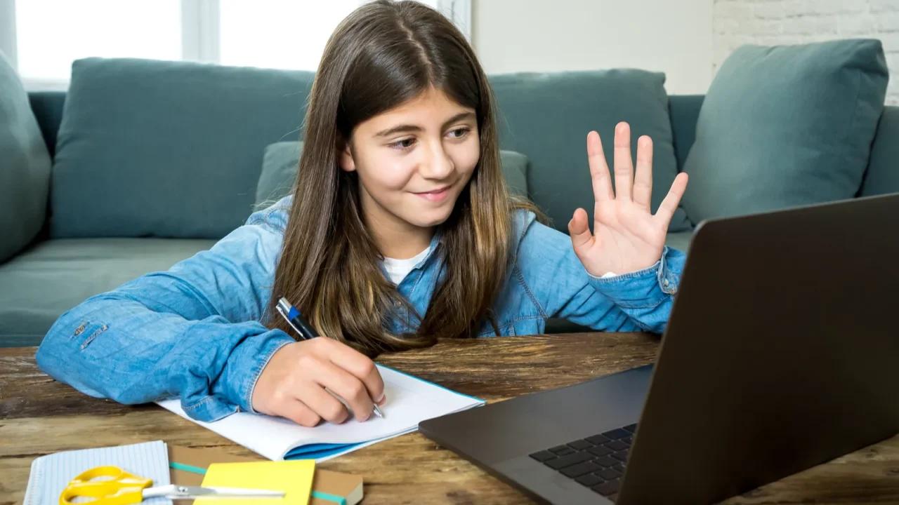 happy teen girl on laptop studying online in virtual remote