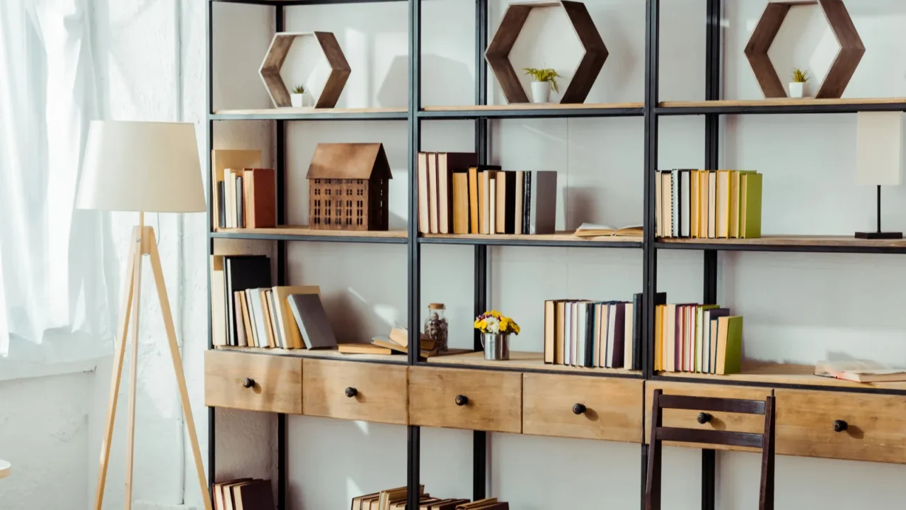 Interior of living room with book shelf and lamp.