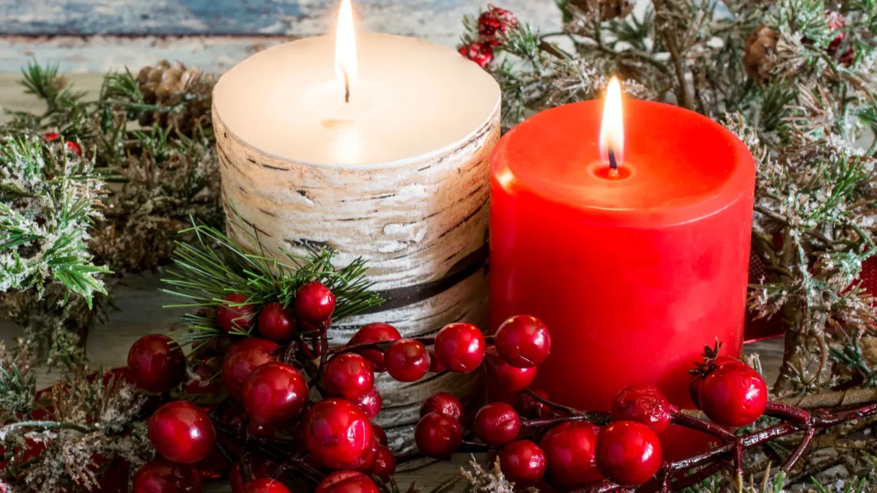 lit candle and a stick of cranberries