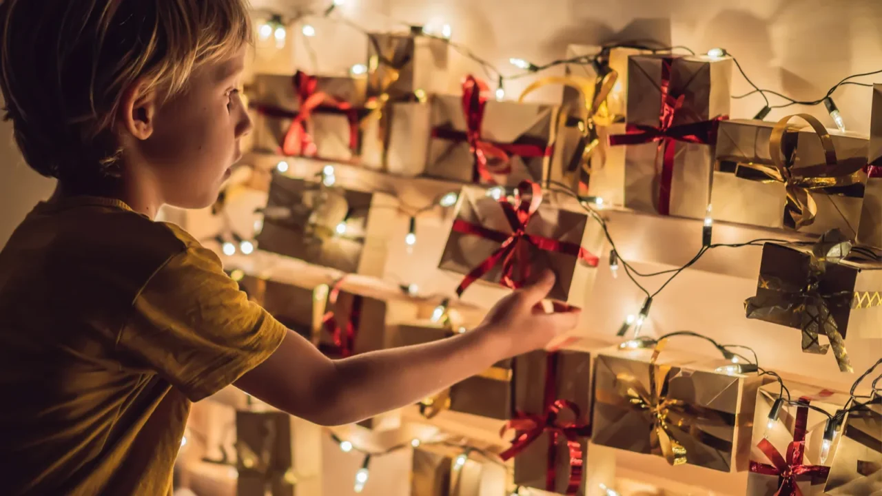 little boy opening gift from christmas advent calendar