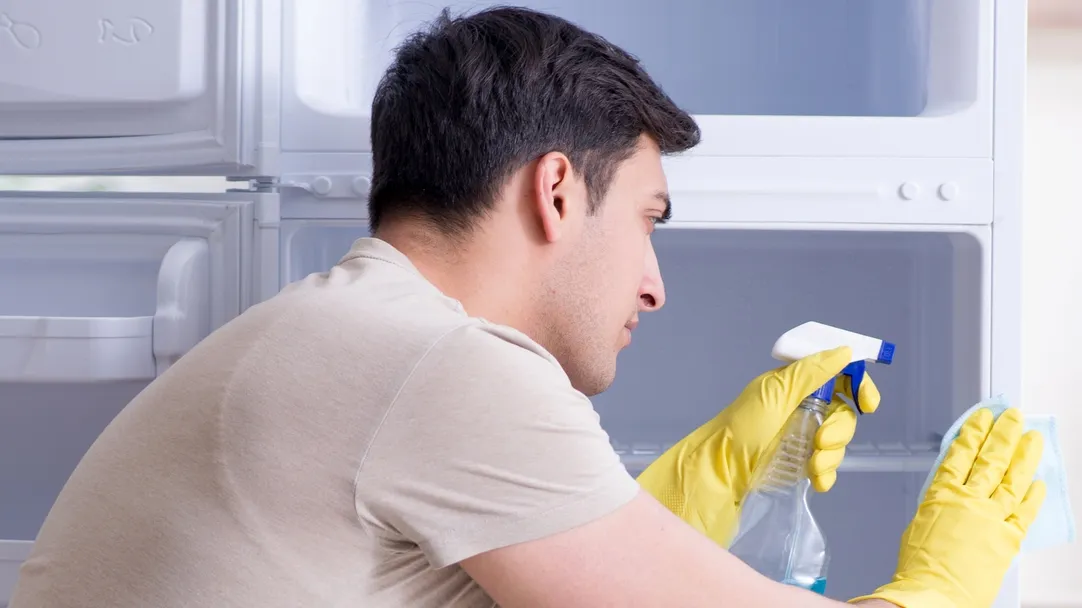 man cleaning fridge in hygiene concept