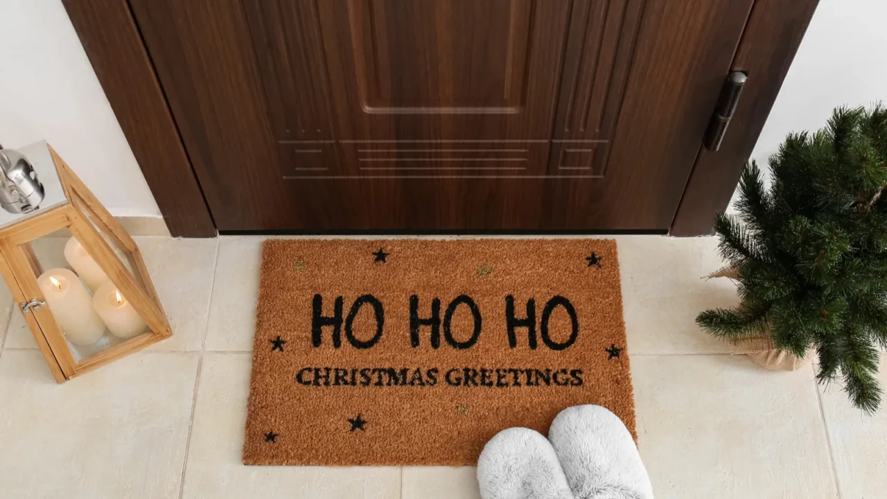 mat with christmas greeting slippers candles and small fir tree