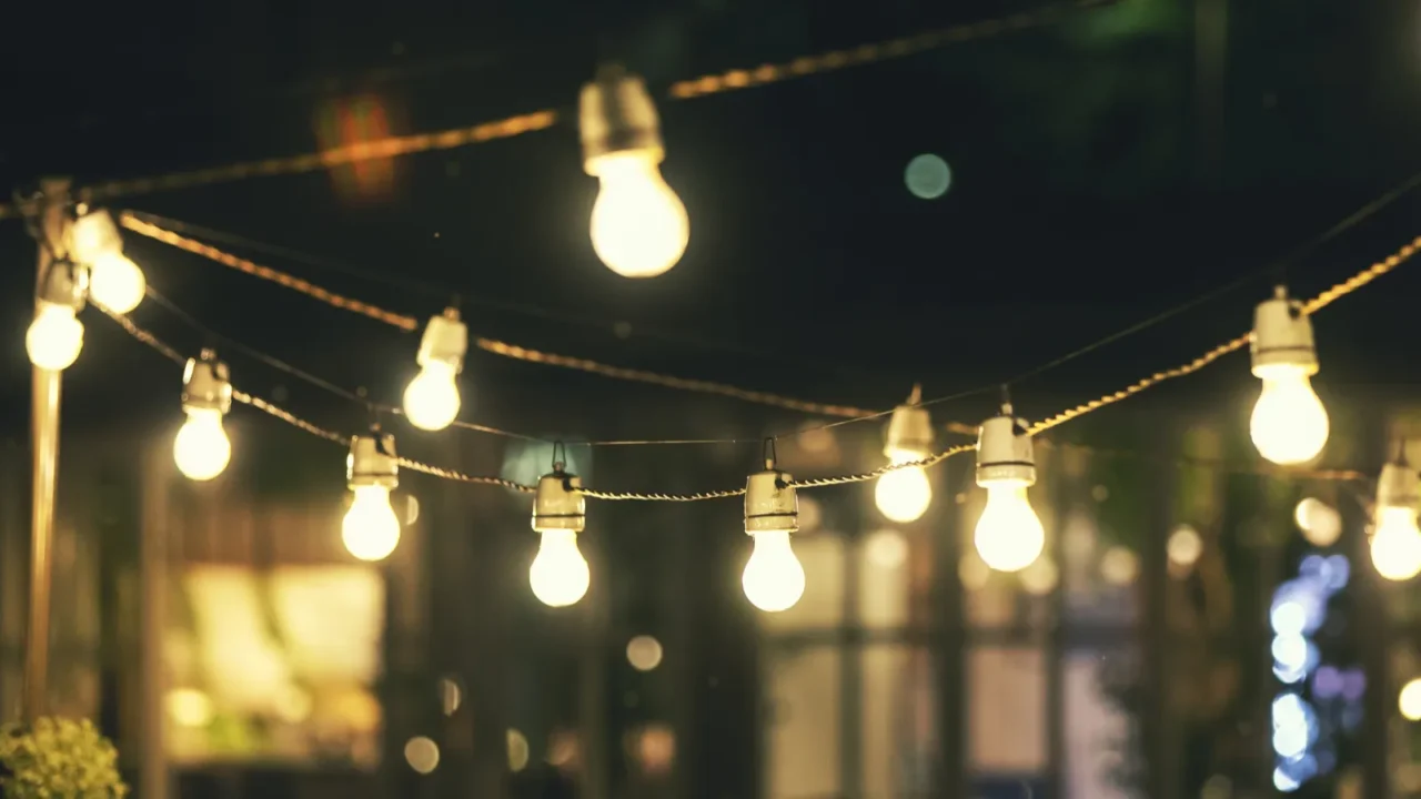 Outdoor party string lights glowing at night.