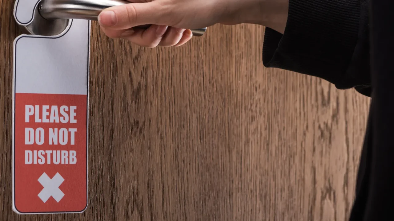 partial view of woman holding door handle with please do